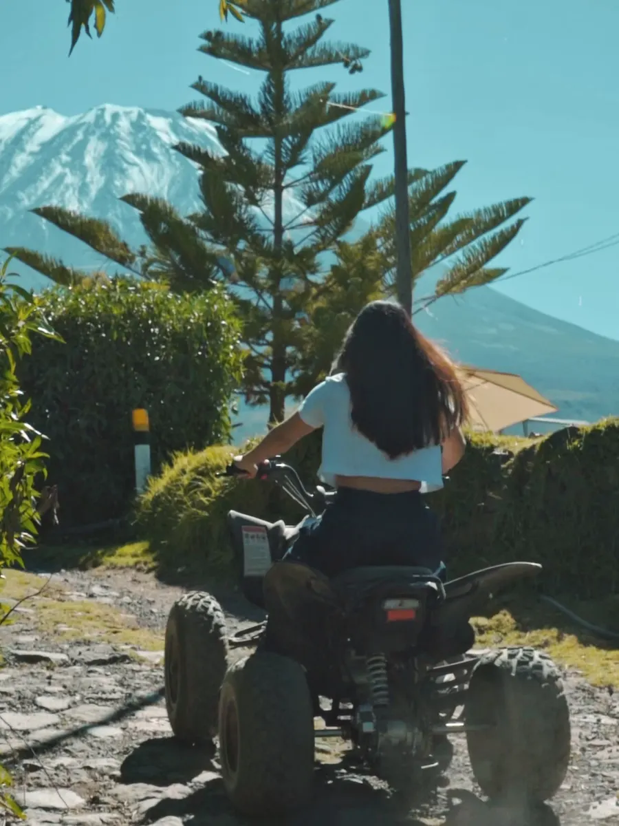 Persona en cuatrimoto con el volcán al fondo